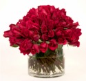 100 red Roses proclaiming her beauty ... topping a low glass cylindrical vase.